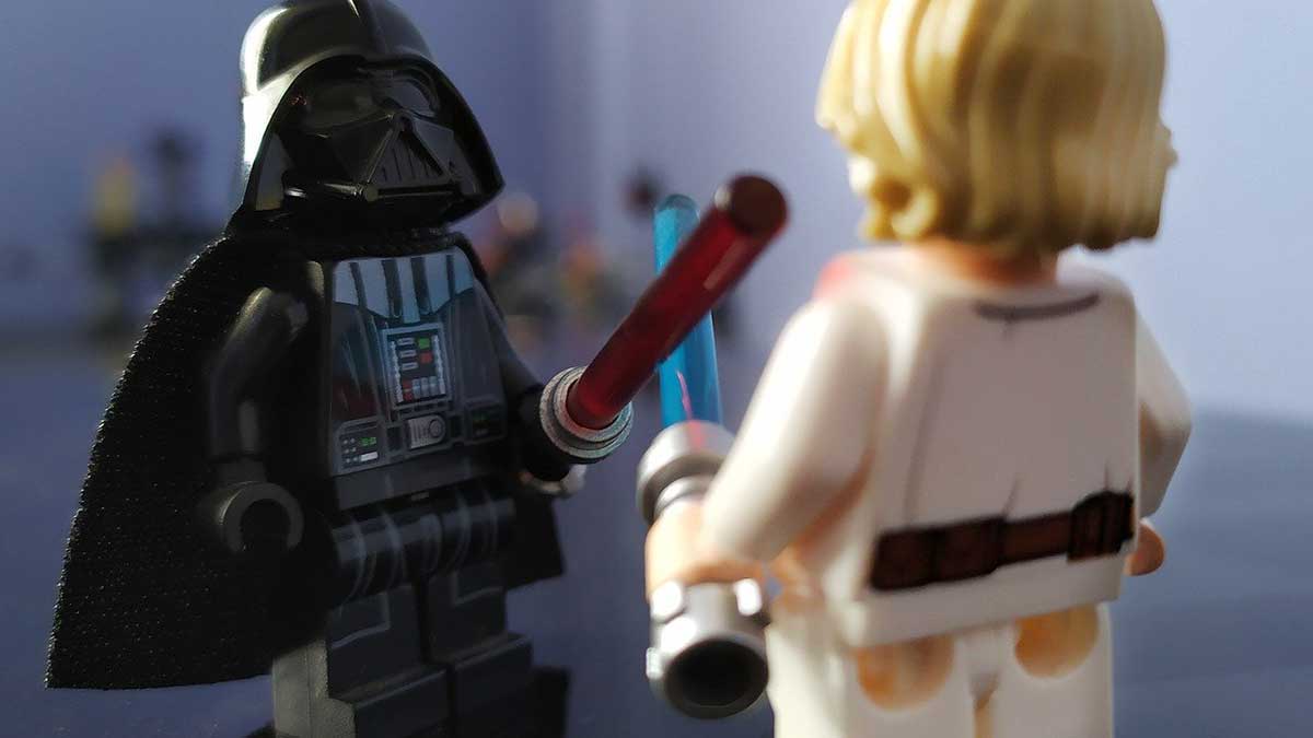 toy characters darth vader and luke skywalker battle good versus evil.