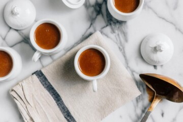 Cups of coffee in white mugs on a marble kitchen counter