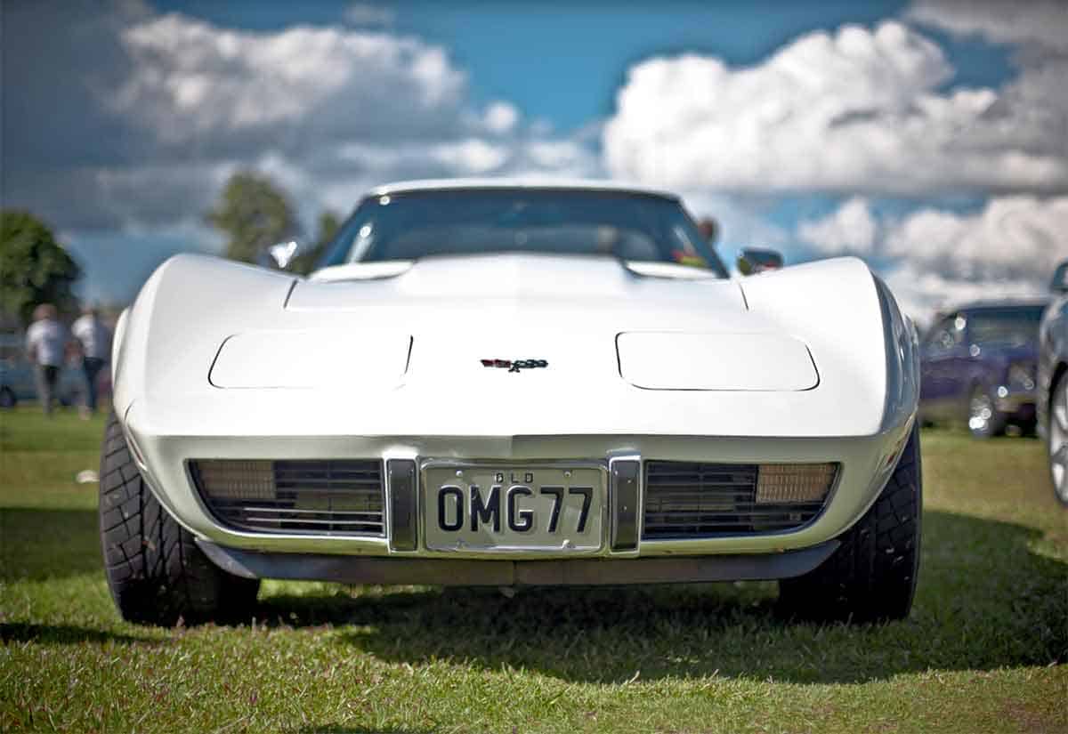 vintage white corvette with OMG license plate.