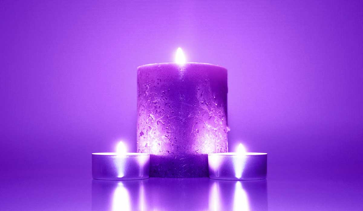 3 purple candles lit and glowing.