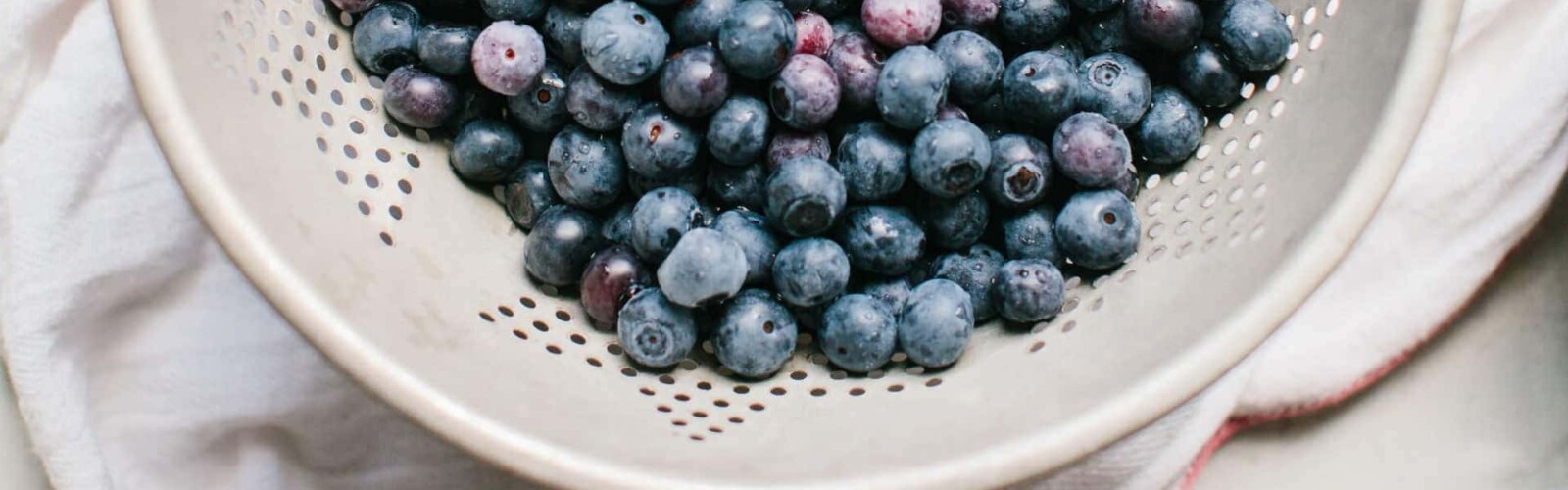 Blueberries in a while bowl about to be washed for making blueberry pie