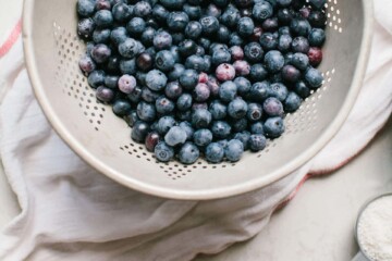 Blueberries in a while bowl about to be washed for making blueberry pie